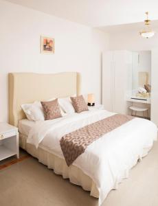 Un dormitorio blanco con una cama grande y una mesa en Muscat Oasis Residences en Mascate