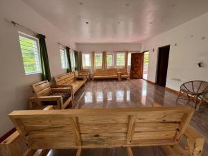 a large room with wooden furniture and windows at Hill Park in Ooty