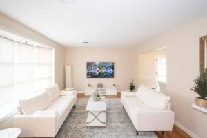 a living room with white furniture and a large window at Home in College Park in College Park