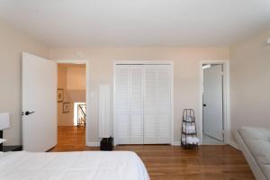una camera da letto con pareti bianche, un letto e pavimenti in legno di Home in College Park a College Park