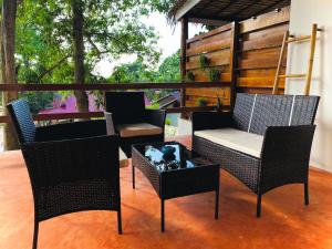 d'une terrasse avec trois chaises, une table et une table. dans l'établissement Ocean Vibes, à Thongsala
