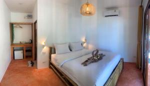 a bedroom with a large white bed in a room at Ocean Vibes in Thongsala