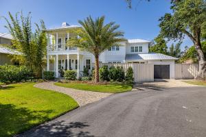 a white house with a palm tree and a driveway at Ocean Pearl in Saint Simons Island