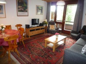 ein Wohnzimmer mit einem Sofa und einem Tisch in der Unterkunft Des Alpes in Davos