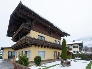 a house with a wooden roof in the snow at Exclusive panoramic apartment in Niedernsill in Niedernsill