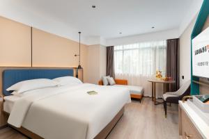 pokój hotelowy z dwoma łóżkami i telewizorem w obiekcie Guangzhou Yilin Hotel w Guangzhou