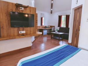 een grote kamer met een televisie aan de muur bij Royals Moonlight Resort,Corbett in Rāmnagar