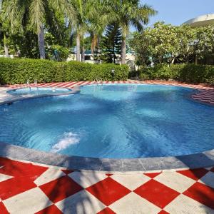 - une grande piscine d'eau bleue dans un complexe dans l'établissement Royals Moonlight Resort,Corbett, à Rāmnagar