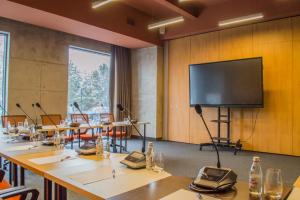 a conference room with tables and a large screen at SADU hotel in Almaty