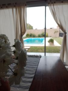 a bunch of flowers sitting on a table next to a window at Quinta EL SECRETO in Olavarría
