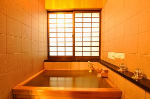W łazience z oknem znajduje się duża wanna. w obiekcie Koshi no yado Takashimaya w mieście Niigata