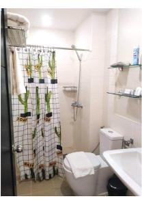 巴科洛德的住宿－Condo with direct access to shopping mall in Bacolod City，浴室设有卫生间和植物淋浴帘