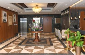 a lobby with a waiting area with flowers on a table at Renee Suites in Jeddah