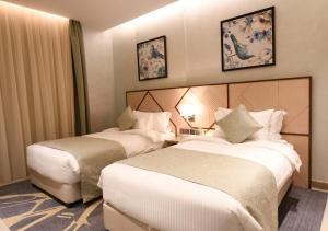 een hotelkamer met 2 bedden in een kamer bij Renee Suites in Jeddah