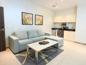 a living room with a blue couch and a table at Renee Hotel in Jeddah