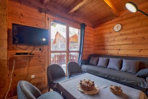 a living room with a couch and a table with a cake on it at Le chalet Virginie in Le Dévoluy