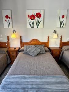 1 dormitorio con 2 camas y 2 cuadros en la pared en Hotel Reyesol, en Fuengirola