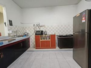 a kitchen with red cabinets and a stainless steel refrigerator at OneB Homestay Shah Alam in Shah Alam