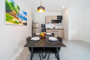 a kitchen and dining room with a table and chairs at Sanook Villas -Geng Mak Nai Harn in Rawai Beach