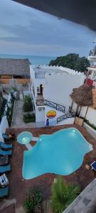 a blue swimming pool in front of a white building at Nungwi ocean view in Nungwi