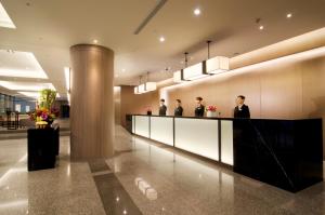 a lobby with people standing at a reception counter at Howard Civil Service International House in Taipei