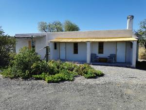 a small white house with a tin roof at Silwerkaroo Gastehuis in Klaarstroom