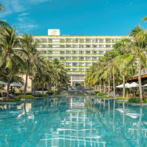 un gran hotel con palmeras delante en Rosa Alba Resort & Villas Tuy Hoa en Tuy Hoa