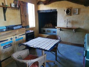 a small kitchen with a table and a stove at Silwerkaroo Gastehuis in Beaufort West
