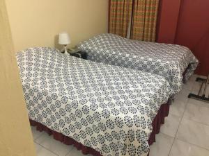 a bed with a black and white blanket on it at Pogas Inn in Kingston