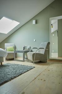 a living room with two chairs and a table at B&B Maas en Heuvel Maastricht in Maastricht