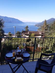 una mesa en un balcón con vistas al agua en Casa giardino panoramico, en Cannero Riviera