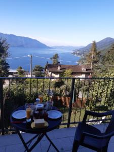 a table on a balcony with a view of the water at Casa giardino panoramico in Cannero Riviera