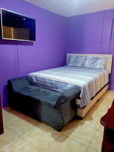 a purple bedroom with a bed and a tv at 3bedrm, 2 bthrm. 7East Greater Portmore in Portmore