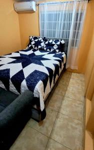 a bedroom with a black and white bed and a window at 3bedrm, 2 bthrm. 7East Greater Portmore in Portmore