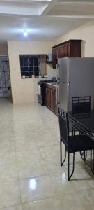 a kitchen with a refrigerator and a bench in it at 3bedrm, 2 bthrm. 7East Greater Portmore in Portmore