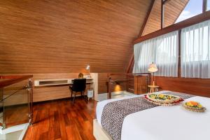 Kanhara Villas Ubud by Pramana Villas في أوبود: غرفة نوم فيها سرير ومكتب