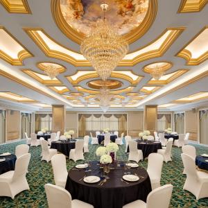 a banquet hall with tables and chairs and a chandelier at Vivanta Thiruvananthapuram in Trivandrum