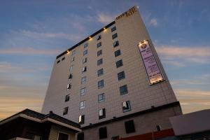 a tall building with a sign on the side of it at Brown Dot Hotel Hadan in Busan