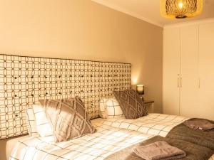 1 dormitorio con 2 camas y cabecero grande en Witsand Whalecliff accommodation en Witsand