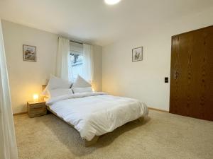 Schlafzimmer mit einem Bett mit weißer Bettwäsche und einem Fenster in der Unterkunft Ferienwohnung Sonnenglück in Bad Peterstal-Griesbach