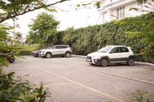 trzy samochody zaparkowane na parkingu obok budynku w obiekcie Port Muziris, A Tribute Portfolio Hotel w mieście Nedumbassery