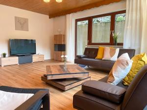 ein Wohnzimmer mit einem Sofa und einem TV in der Unterkunft Ferienwohnung Sonnenglück in Bad Peterstal-Griesbach