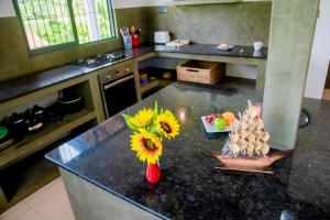 a kitchen with a counter with a vase with sunflowers on it at Peaceful Villa with pool near Hikkaduwa in Ambalangoda