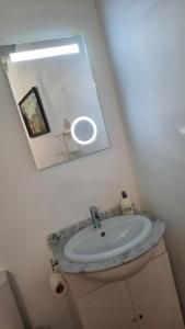 ein Badezimmer mit Waschbecken und Spiegel in der Unterkunft Maison du Coquelicot in Tourouzelle + 56 Fotos
