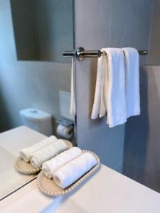 - une salle de bains avec des serviettes blanches sur un comptoir dans l'établissement Royal Park Lodge, à Auckland