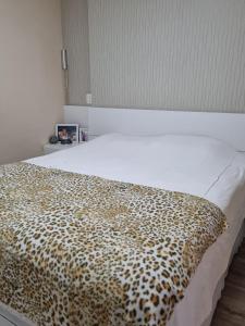 un letto con una coperta leopardata sopra di Apto 222 ótima localização a São Roque