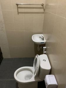 La salle de bains est pourvue de toilettes et d'un lavabo. dans l'établissement Tirtasuci House, à Kuta