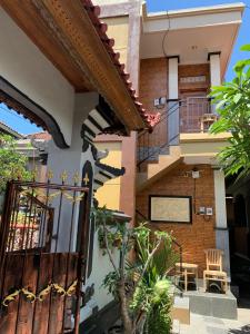 a house with a gate and a balcony at Tirtasuci House in Kuta