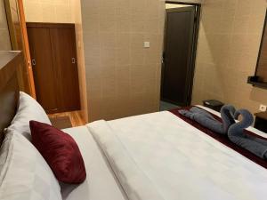 a bedroom with a bed with red pillows on it at Tirtasuci House in Kuta