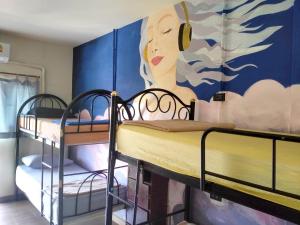 two bunk beds in a room with a mural at WET! a Pool Party Hostel by Wild & Wandering in Haad Rin